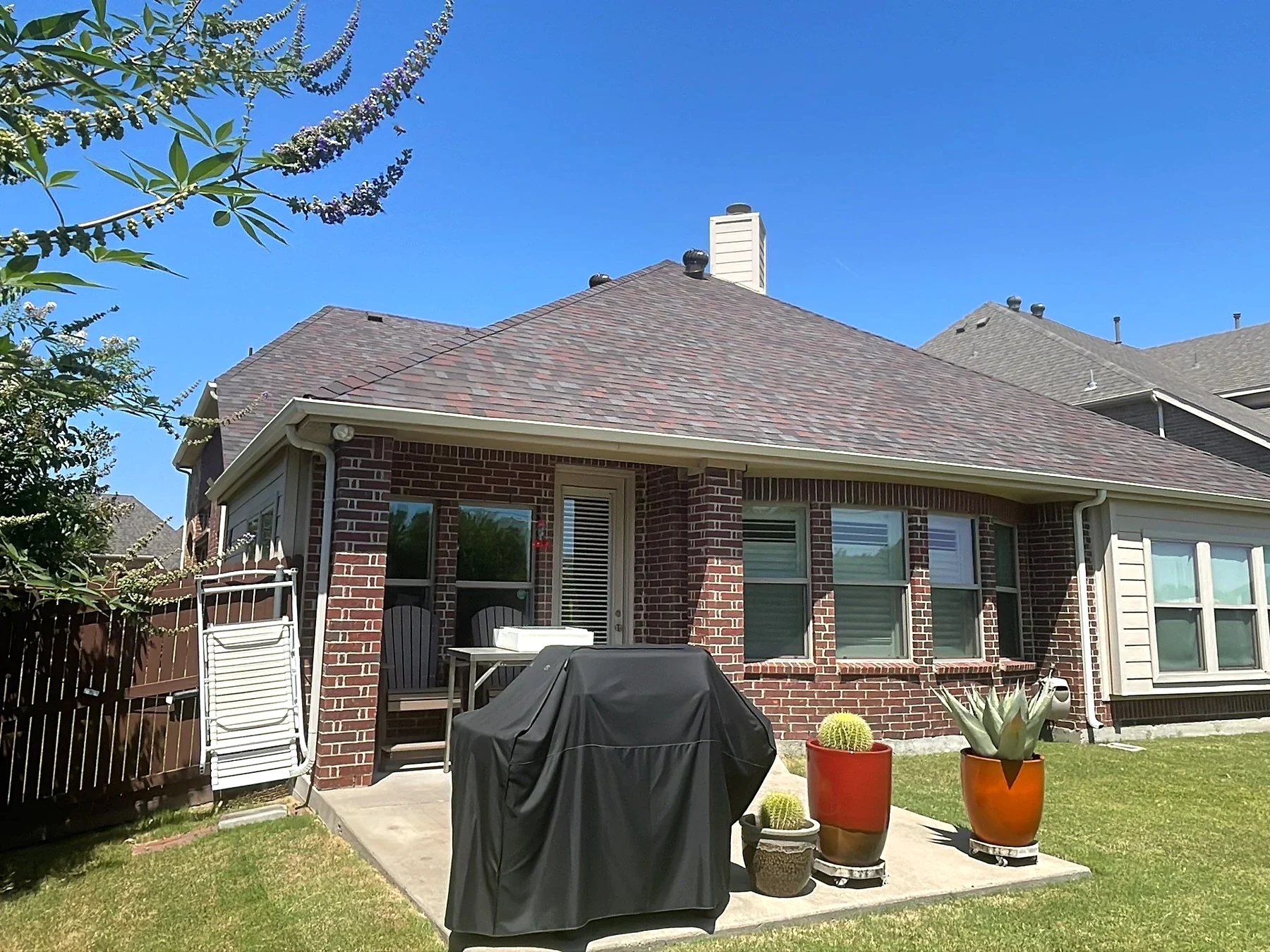 Brick home exterior and shingle roof photographed on a Pioneer Roofing project